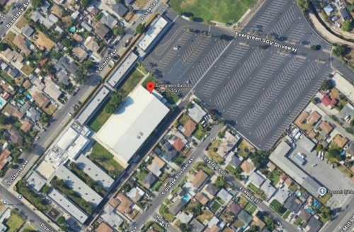 Aerial view of a parking lot and a building. Description automatically generated